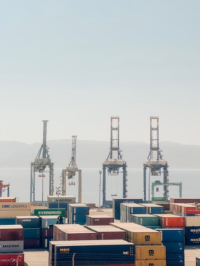 hero-img-02 Cranes and shipping containers at Aqaba Port, Jordan, on a clear day.