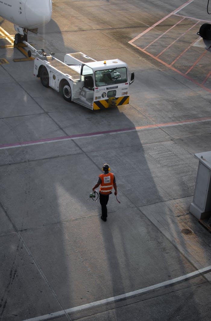 ours-journey An airport worker walks on the runway in Minas Gerais, Brazil, during sunset.