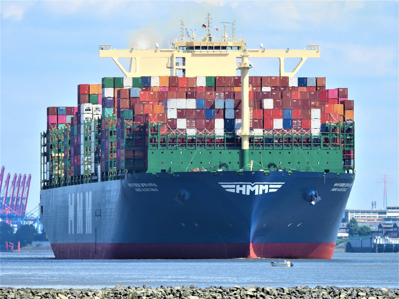 services-01 Front view of a massive cargo ship loaded with containers in Hamburg's harbor.